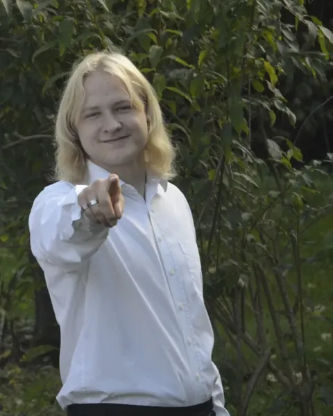Martin zeigt lächelnd in die Kamera
