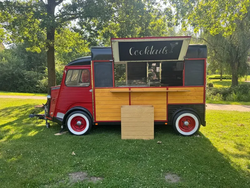 Unser Wagen von der Seite auf einer Wiese, die Verkaufsklappe ist geöffnet